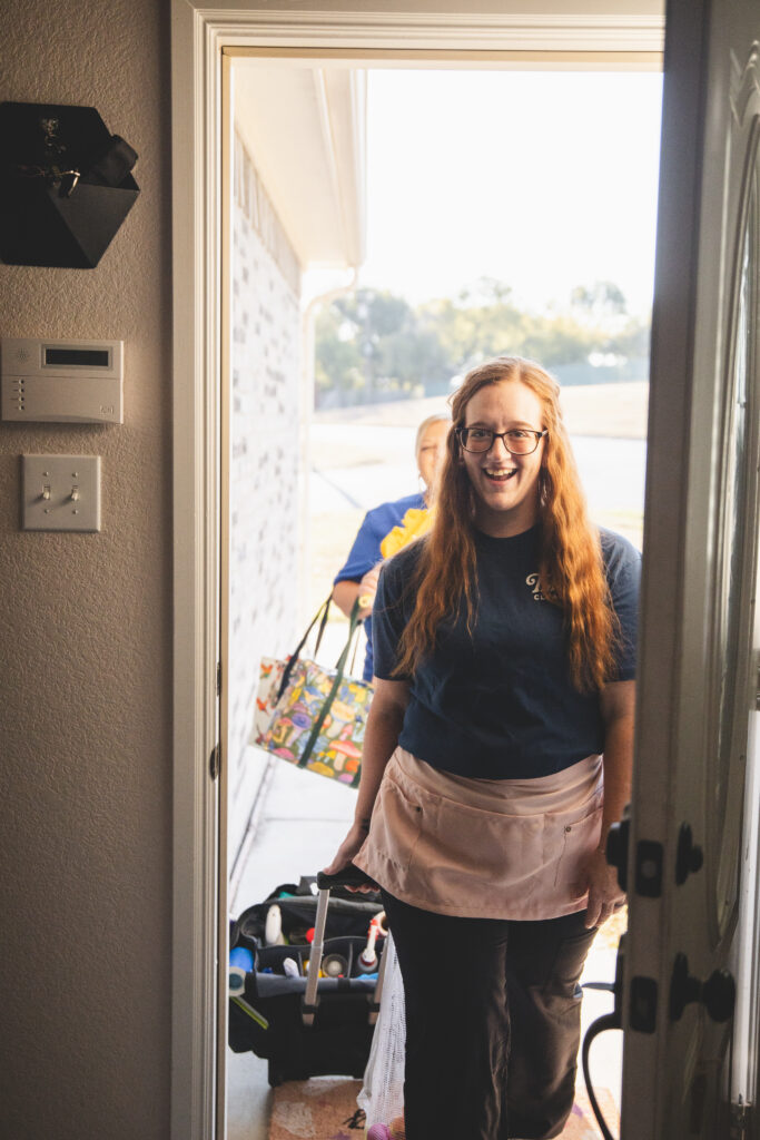 Two cleaners from The Mop & Broom walking in through a client's front door in Fort Worth