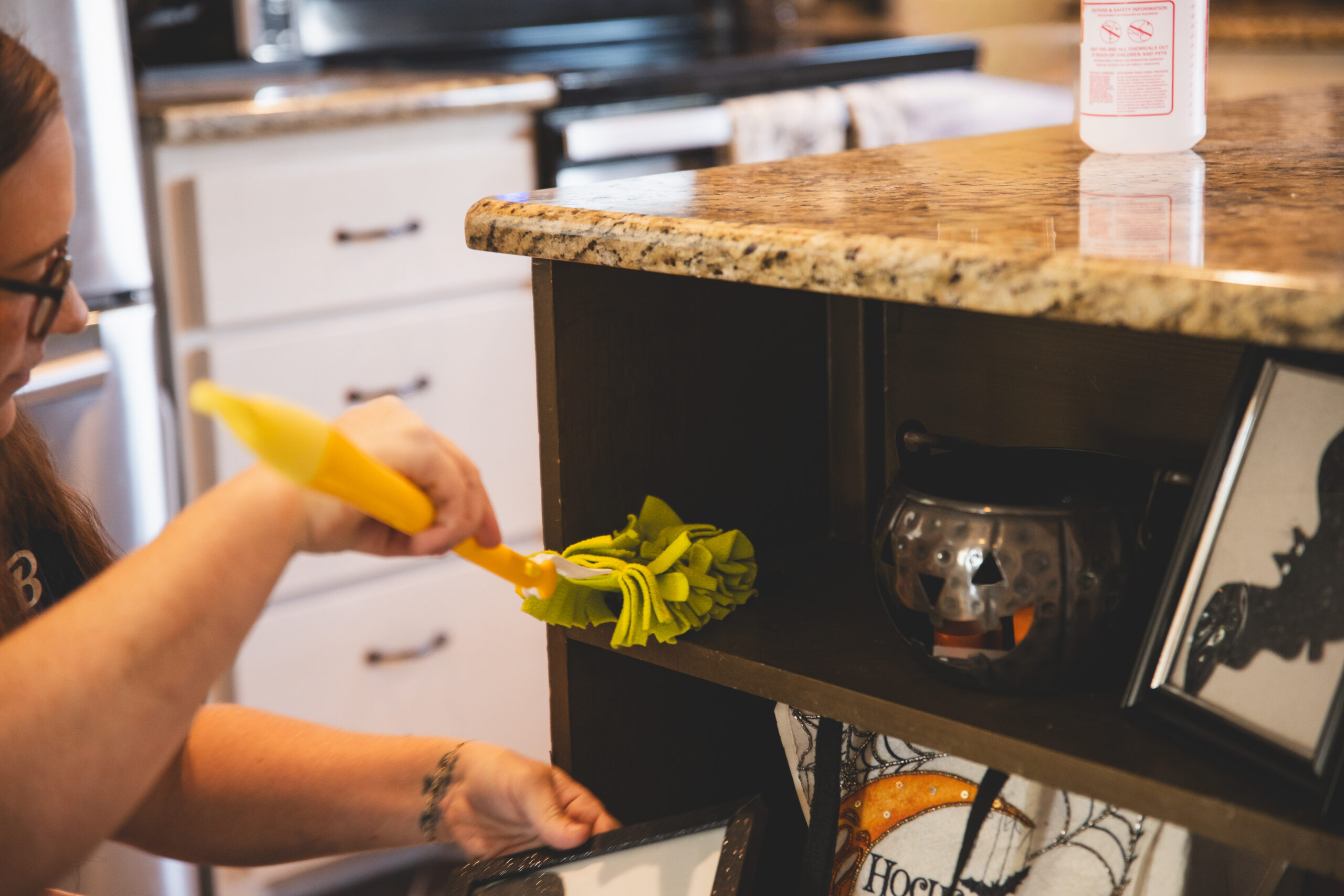 Professional residential cleaning service by The Mop & Broom near me, showcasing a cleaner in a kitchen.
