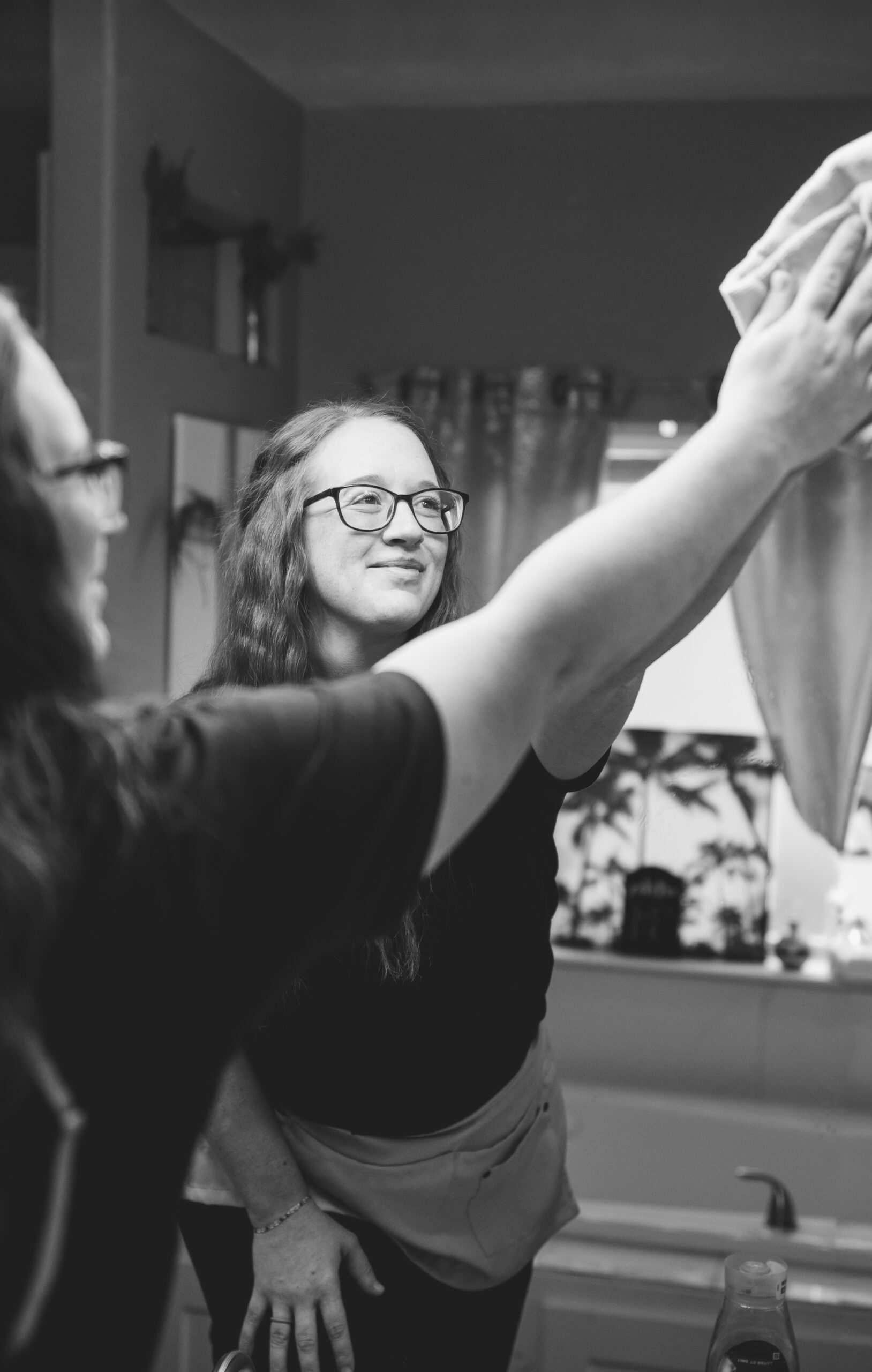 A professional cleaner providing home cleaning services near me with a smile at The Mop & Broom