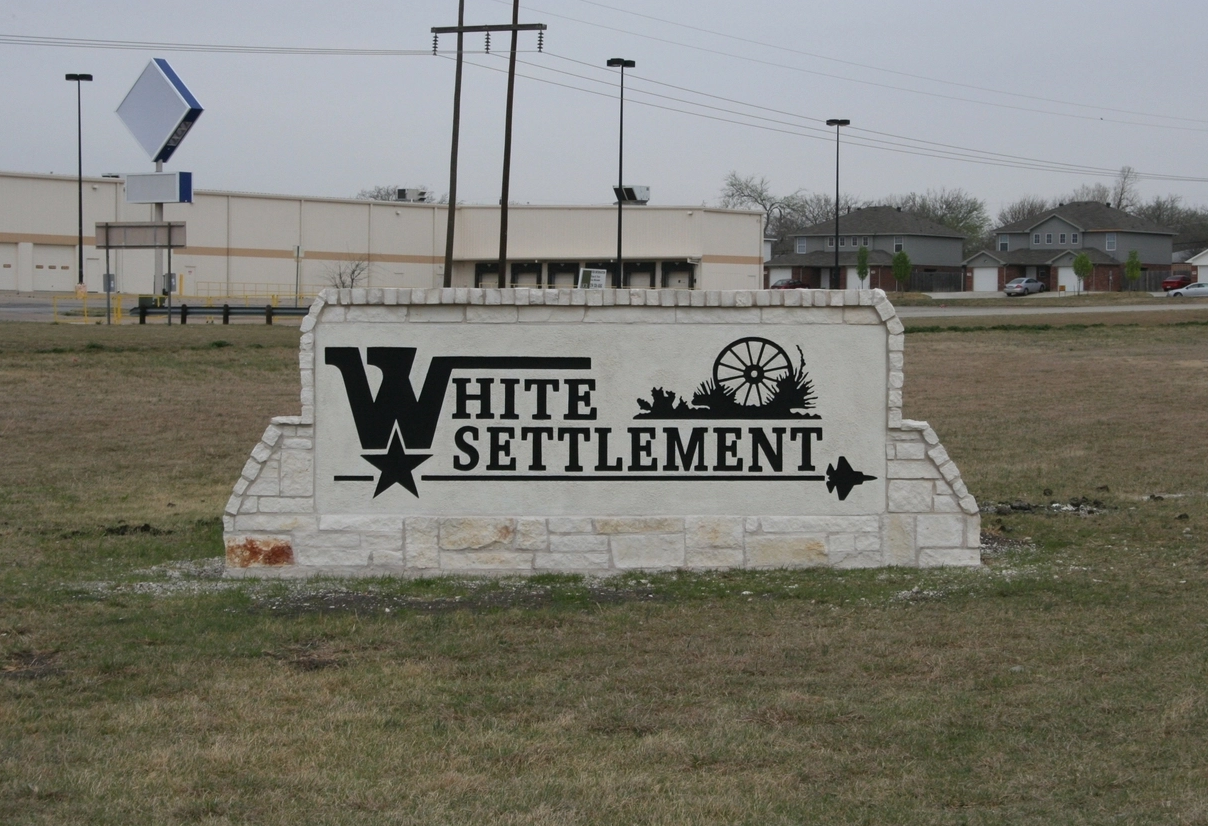 A worker from The Mop & Broom cleans a kitchen sink in Burleson, showcasing their professional cleaning services.